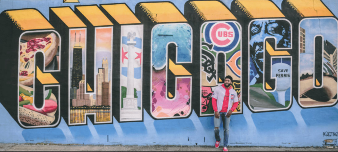 About Banner Man standing by wall art saying "Chicago"
